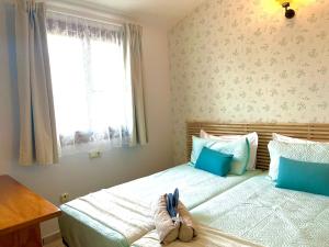 una camera da letto con due letti e una finestra di La Casita Bonita del Faro Holiday Retreat in Gran Alacant a Gran Alacant Altre 29 foto