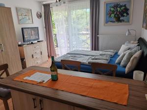 a room with a bed and a bottle of wine on a table at Beatrix apartman in Balatonőszöd