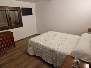 a small bedroom with a bed and a dresser at La Cabaña in Redondela