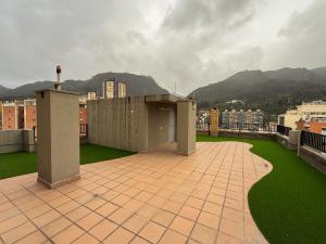 a building on a roof with green grass and buildings at Casa Mila - Alma Hotels in Bogotá