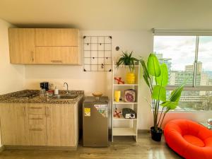 a kitchen with a sink and a refrigerator at Casa Mila - Alma Hotels in Bogotá