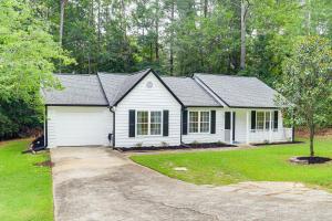 a white house with a garage in a yard at Walk to Dtwn Woodstock Modern Home with Patio! in Woodstock