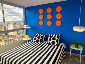 a blue room with a bed and a window at Casa Mila - Alma Hotels in Bogotá