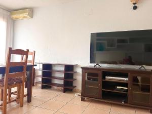 un soggiorno con TV a schermo piatto su un centro di intrattenimento in legno di La Casita Bonita del Faro Holiday Retreat in Gran Alacant a Gran Alacant