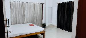 a small room with a bed and black curtains at Ade's Homestay in Guwahati