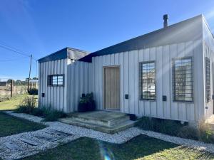 ein weißes Haus mit einer Tür und einem Hof in der Unterkunft Casa Laura - Casa en Chapa zona Cruz del Sur para 5 PAX - Hola Sur in Chapadmalal