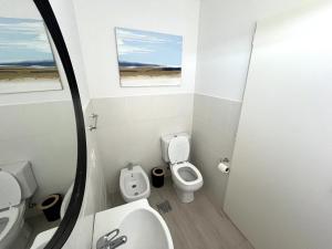 ein Badezimmer mit Toilette, Waschbecken und Spiegel in der Unterkunft Casa Laura - Casa en Chapa zona Cruz del Sur para 5 PAX - Hola Sur in Chapadmalal + 11 Fotos