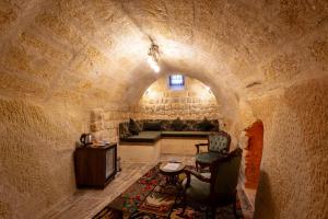 a living room with a couch in a stone wall at Lagoon Cave Suites in Urgup