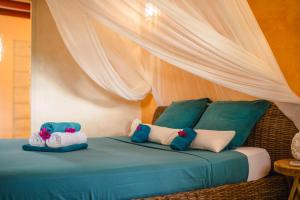a bed with two stuffed animals on top of it at Evasion tropicale villa 6 personnes avec piscine in Saint-Louis