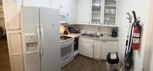 a white kitchen with white cabinets and a refrigerator at 3 Bedrooms Florida Sunshine in Pompano Beach