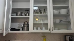 a kitchen cabinet filled with dishes and utensils at 3 Bedrooms Florida Sunshine in Pompano Beach