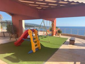 a playground with a slide and a swing at Modern Seaview Apartment with a Pool in Dobra Voda