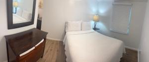 a small bedroom with a bed and a mirror at 3 Bedrooms Florida Sunshine in Pompano Beach +2 photos