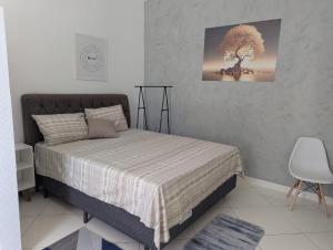 a bedroom with a bed with a tree on the wall at Oscar Place in Aracaju