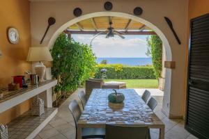 een eetkamer in de openlucht met een tafel en uitzicht op de oceaan bij Villa 19 in Santa Cesarea Terme