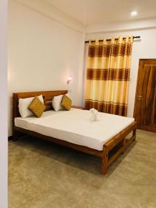 une chambre avec un lit avec des draps blancs et une fenêtre dans l'établissement Wild Safari River Cottage udawalawe, à Uda Walawe