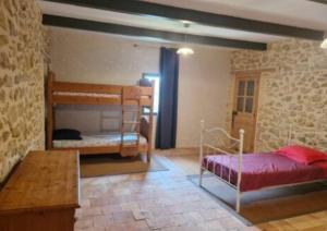 a bedroom with two bunk beds and a table at Grand mas provençal 4 chambres, dortoir 7 pers, idéal familles groupes, fraîcheur d'été in Montfaucon