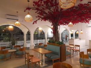 a restaurant with tables and chairs and a tree at Zeleny Santorini in Negombo