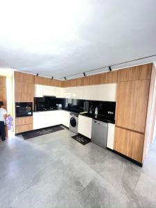a kitchen with wooden cabinets and a washer and dryer at Beachside Bliss: Cozy Surf Villa in Mirleft
