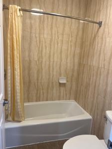 a bathroom with a tub and a toilet and a shower at Carlton Motor Lodge in Los Angeles +5 photos