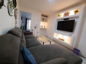 a living room with a couch and a flat screen tv at Vertice in San Luis Potosí