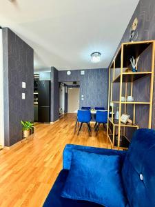 a living room with a blue couch and a table at Andy's apartment in downtown Metropolis with parking in Nivy