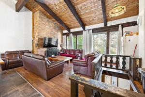 ein Wohnzimmer mit Ledersofas und einem TV in der Unterkunft Margaritaville - Big Space with Lots of fun and Hot Tub 38R in Blue Mountains