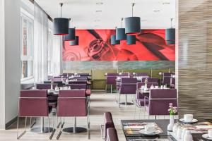 فندق إنترسيتي هامبورغ ألتونا  في هامبورغ: غرفة طعام مع طاولات وكراسي أرجوانية