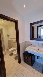 a bathroom with a sink and a toilet and a mirror at Spazio Accogliente dove il tempo si ferma in Livorno