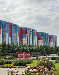 szereg wysokich budynków z kwiatami w parku w obiekcie Элитный Жилой Комплекс Nauryz Park w mieście Szymkent +2 zdjęcia