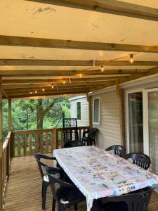 a table and chairs on a screened porch with a table and chairs at Mobil home B1Bis La Pointe LB in Capbreton