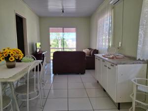 Una cocina y una sala de estar con un sofá y una mesa. en Apartamento Terraço do Sol 01, en Marcelino Ramos