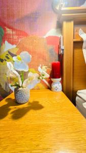a wooden table with a vase with flowers on it at Liza Luxury Holiday Apartment Oceanic 44 in Durban