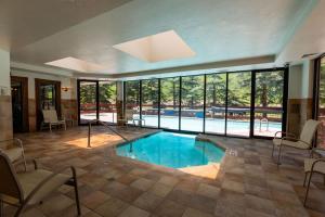 a large swimming pool in a room with windows at Strawberry Park True Ski In Ski Out by Vail Realty in Beaver Creek