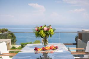 a vase filled with flowers and fruit on a table at Kempinski Villa 100m from Beach in Savudrija +37 photos