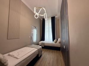 a small room with two beds and a chandelier at Nestroyplatz Rooms I Self Check In in Vienna
