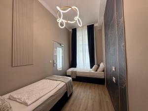 a small room with two beds and a chandelier at Nestroyplatz Rooms I Self Check In in Vienna +62 photos