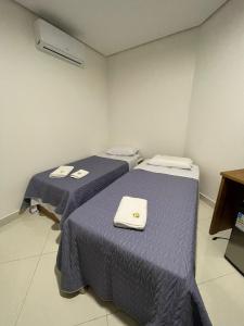 Dos camas en una habitación con sábanas moradas. en Hotel Prime Suites,  1 foto más
