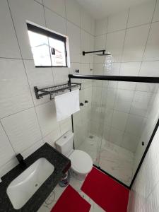 a white bathroom with a sink and a toilet at Hotel Acqua Park in Capim Grosso