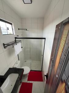 a bathroom with a shower and a toilet and a sink at Hotel Acqua Park in Capim Grosso