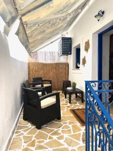 a patio with chairs and tables on a porch at Skalopetra in Pylos