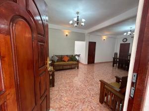 a living room with a couch and a door at Serenity Valley - Tourist Bungalow in Kandy