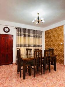 a dining room with a wooden table and chairs at Serenity Valley - Tourist Bungalow in Kandy