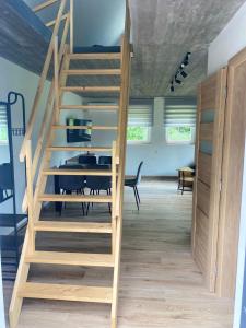 a loft bed in a room with a table at Domki pod Wolinem in Wolin