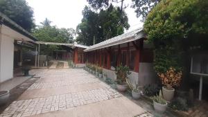 a walkway next to a building with potted plants at The Garden Resort Airport Katunayaka in Katunayake
