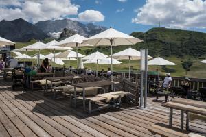 a group of tables and umbrellas on a deck at Berghotel Hahnenmoos in Adelboden