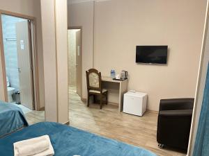 a room with a desk and a chair and a television at Family Hotel Triston in Tbilisi City