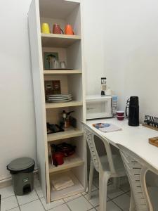 a kitchen with a table and chairs next to a shelf at Manaira Suite 01 in João Pessoa +5 photos