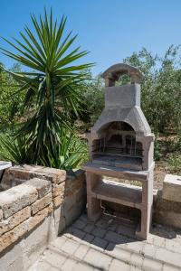 a stone oven in a garden with a palm tree at Riserva-La marea in Vasto