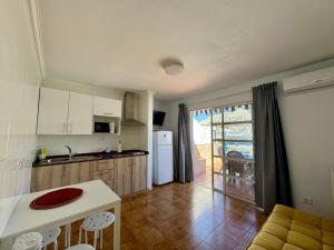 a kitchen with a table and a counter top at La Romana Apartment in Puerto Rico de Gran Canaria +12 photos